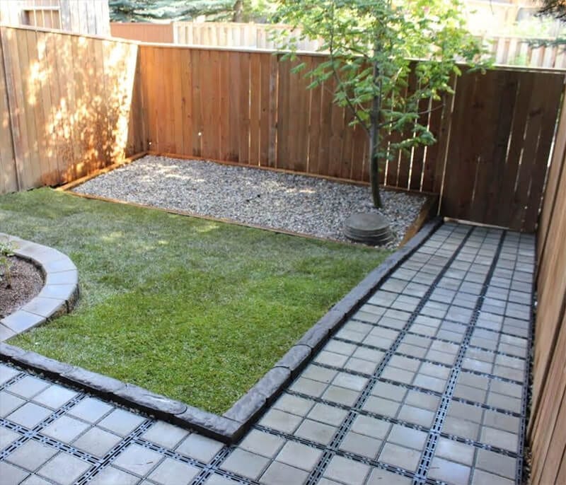 Ecoraster Bloxx permeable pavers installed as a parking surface around a backyard lawn