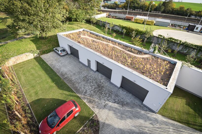 Aerial view of permeable parking beside a garage block with a planted green roof