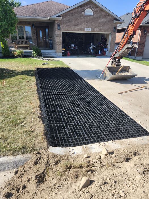 Permeable grid driveway extension being installed beside a concrete driveway in Listowel, Ontario