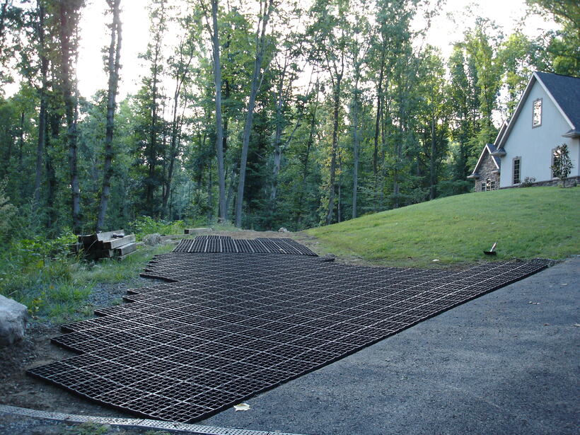 Ecoraster permeable paving grids laid out to extend a sloped cottage driveway before infill